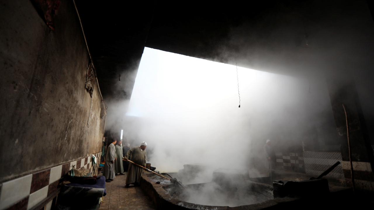 Suyu sıkılan şeker kamışı ısısı yüksek bir tencerede karıştırılıyor.