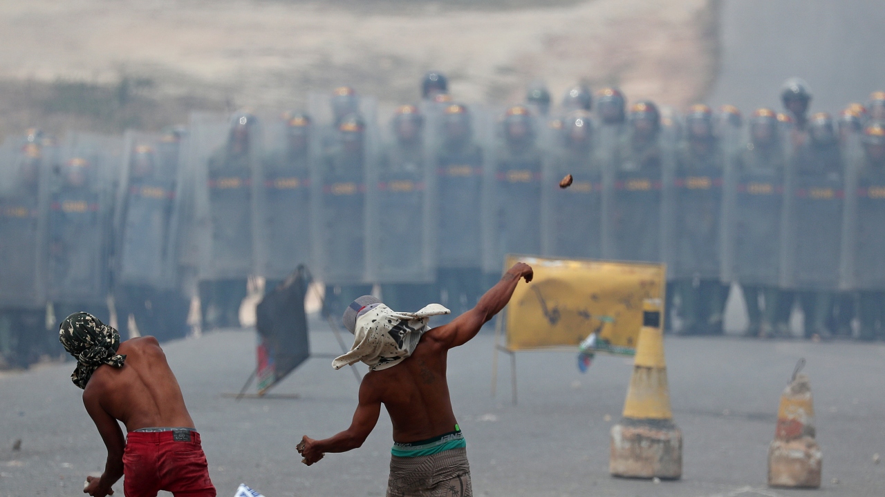 Halat yardımıyla köprüye çıkan ve Kolombiya polisinin kurduğu barikatların önüne geçen grup Venezuela tarafında bekleyen güvenlik güçlerine yaklaşık 3 saat boyunca taş ve molotofkokteyli attı.