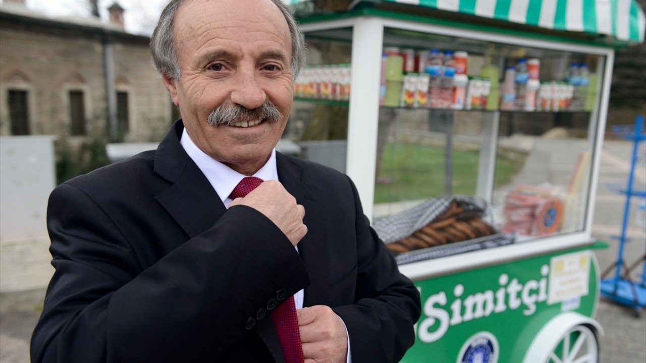 Önünden geçenlerin ilgisini çeken Berksun, kentte "kravatlı simitçi" olarak tanınıyor.