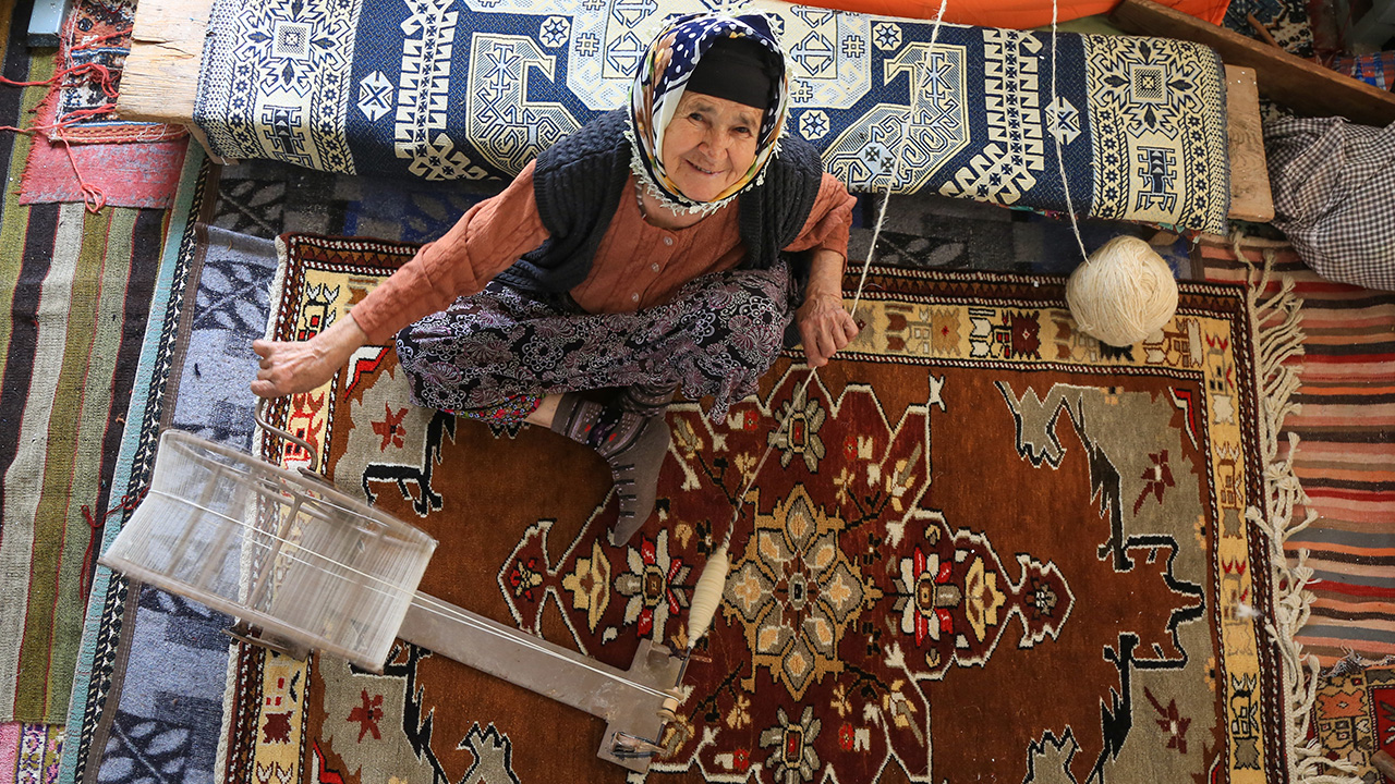 Dağlardan topladıkları kekik, püren gibi otları kaynatarak, eğirdikleri yün iplikleri doğal yöntemlerle boyayan kadınlar, rengarenk ipliklerle tasarladıkları motifleri ilmek ilmek halılara nakşediyor