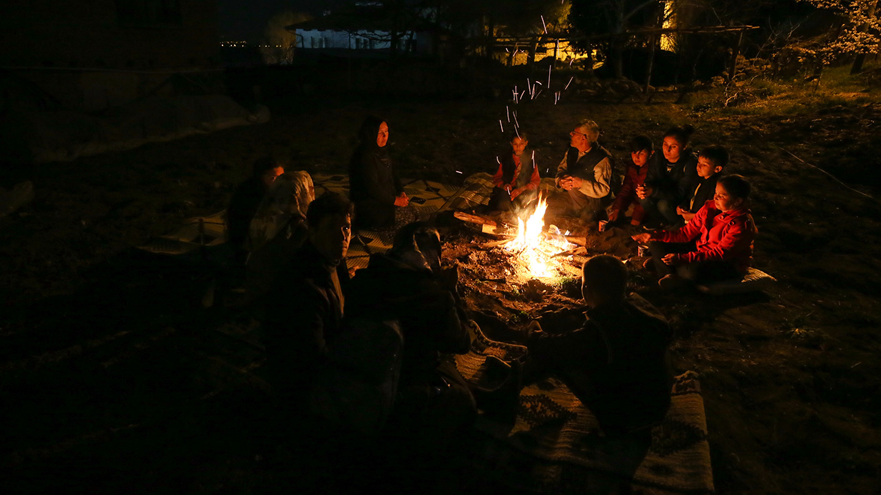 Depremden etkilenen vatandaşlar, geceyi evlerinin önünde kurulan çadırların etrafında ateş yakarak geçiriyor.