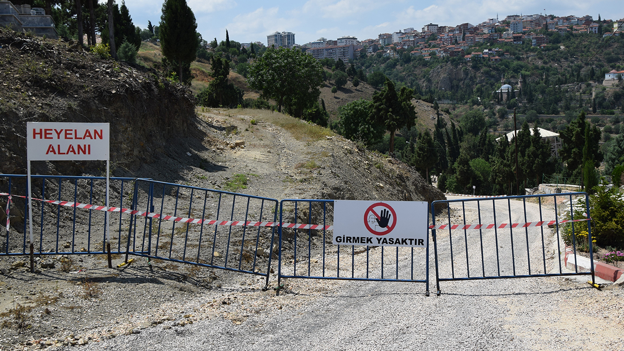 Kentte bir süre önce bazı mezar taşlarının kaymasının ardından son günlerdeki yağışların da etkisiyle mezarlığın yanından geçen yolda toprak kayması meydana geldi.