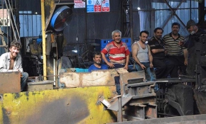 Demir işçileri birbirlerine su tutarak serinliyor