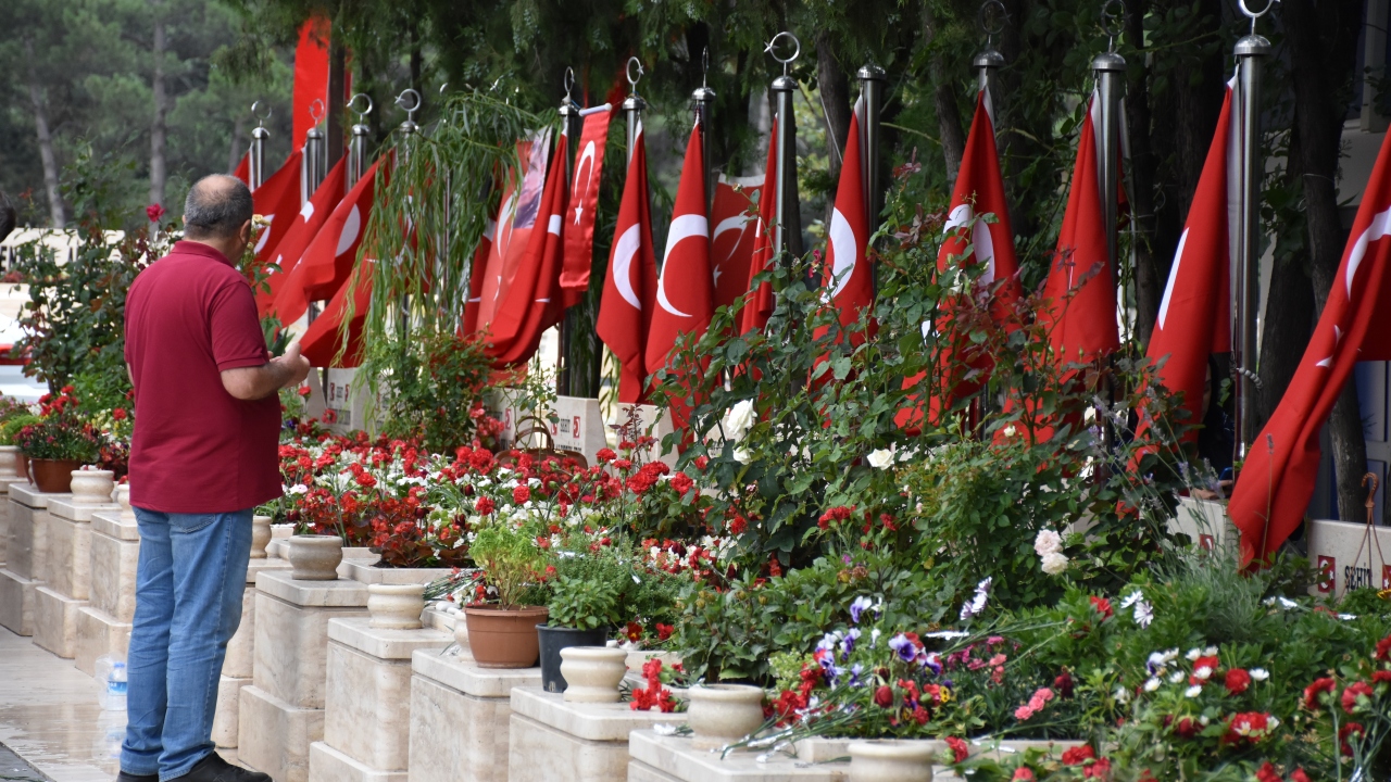 Aileler, Türk bayrakları asılı kabirlerin başında dua etti. 