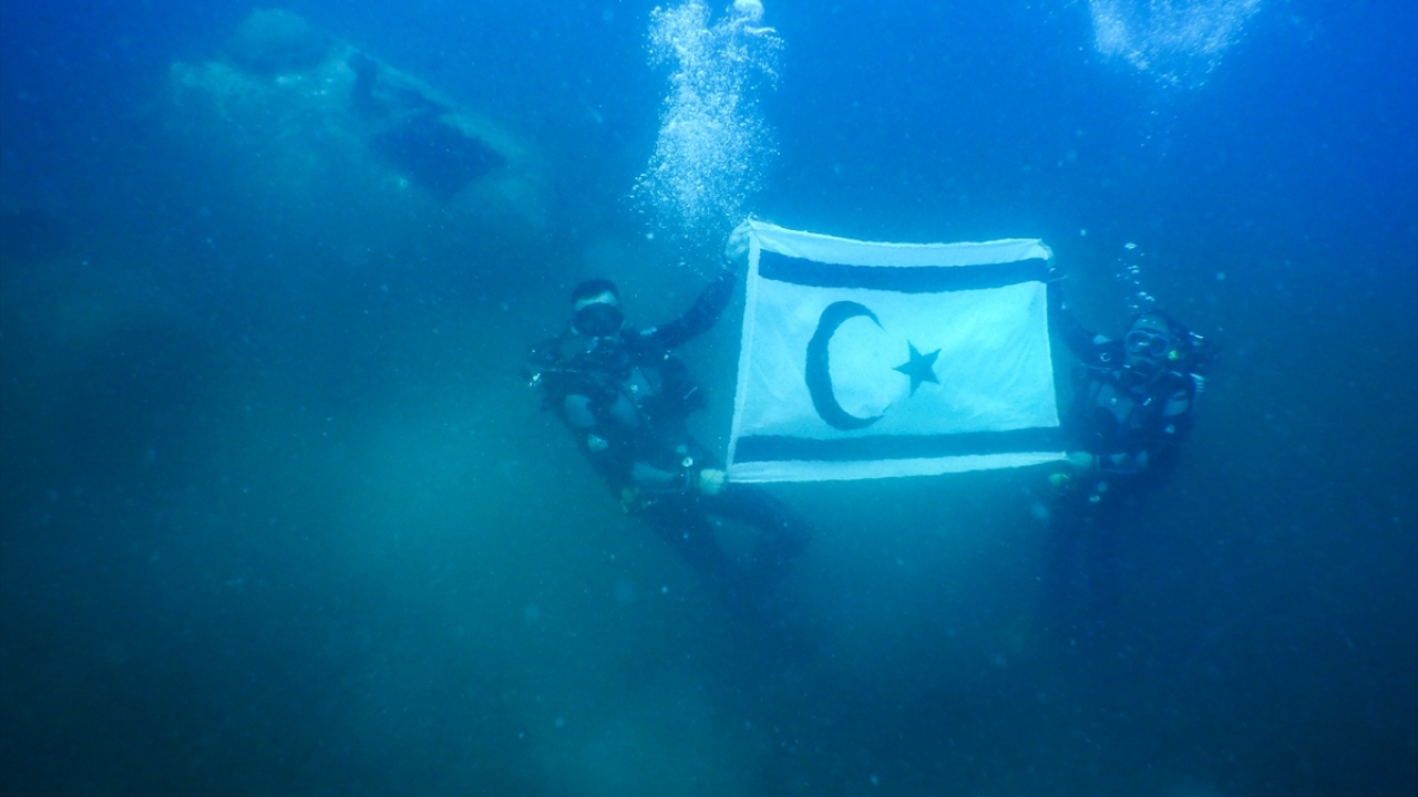 Uçak etrafından birkaç tur atan ve deniz canlılarına yuva olan uçağı inceleyen tim, daha sonra 18 metre derinlikte Türk ve KKTC bayrağı açtı.
