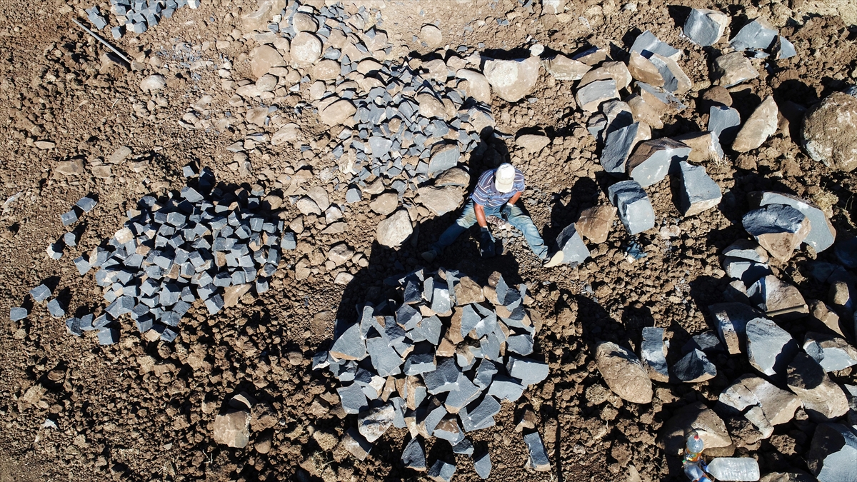 İşçiler, hava sıcaklığının 45 dereceye kadar yükseldiği ilçede, taşlara şekil vermek için uğraşıyor.