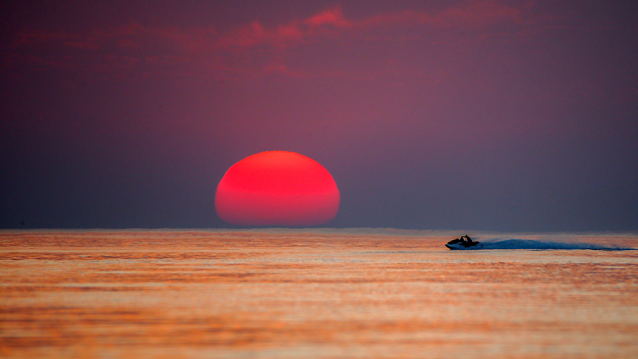 Van Gölü`nün Edremit ilçesi kıyısında açılan halk plajına gelen ziyaretçiler, gün batımında jet skiye binmenin keyfini çıkarıyor.
