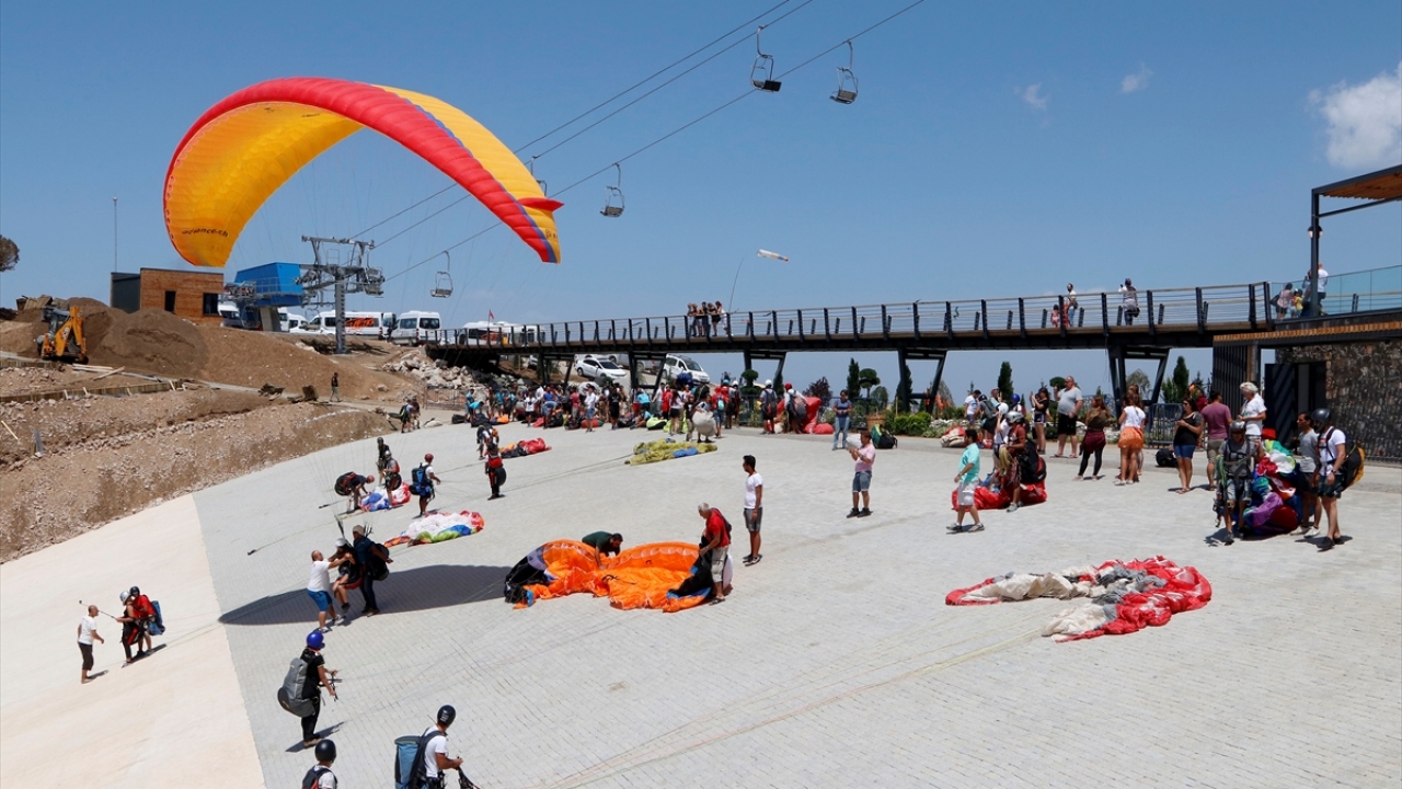Adrenalin tutkunu tatilciler, pilotların yaptığı akrobasi hareketleriyle 2 bin metre yükseklikte heyecan dolu dakikalar geçiriyor.