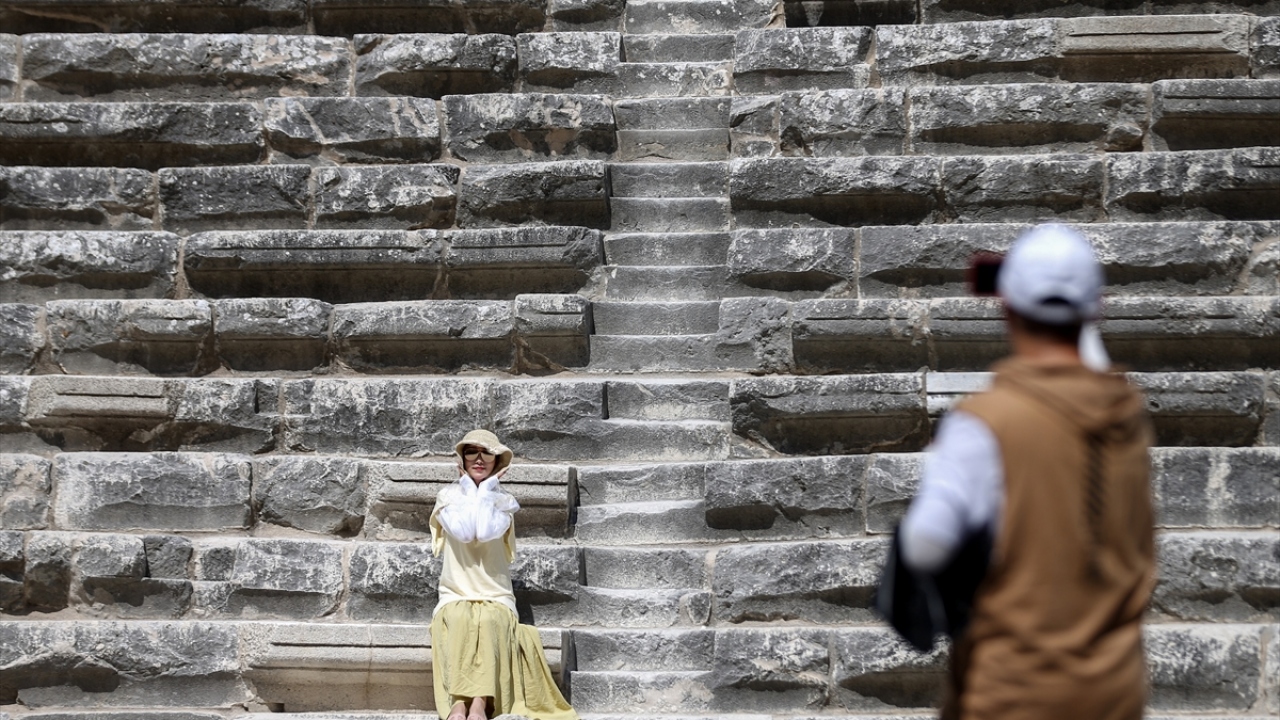 Tiyatroyu ilgiyle gezen ziyaretçiler, doğal bir stüdyoyu andıran tarihi yapıda fotoğraf çektiriyor.