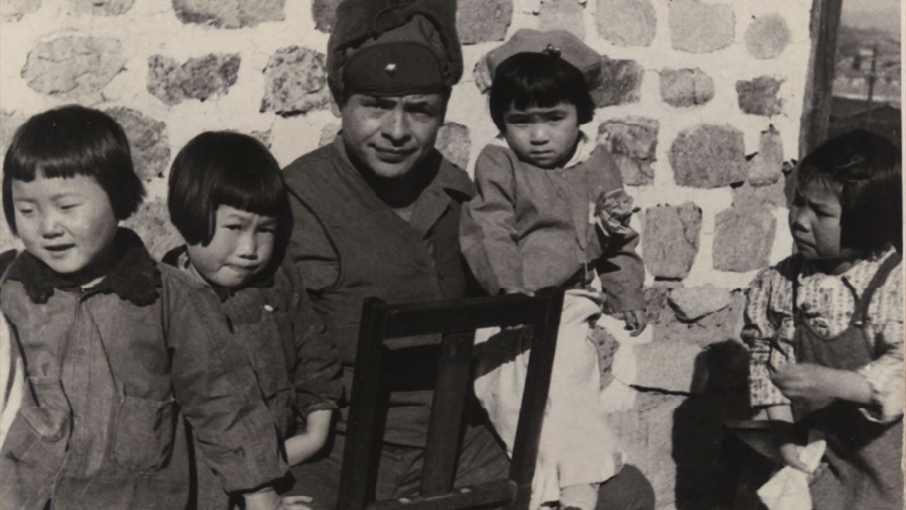 Yetim kalan Koreli çocuklarla fotoğraf çektiren Türk askeri. (Arşiv)