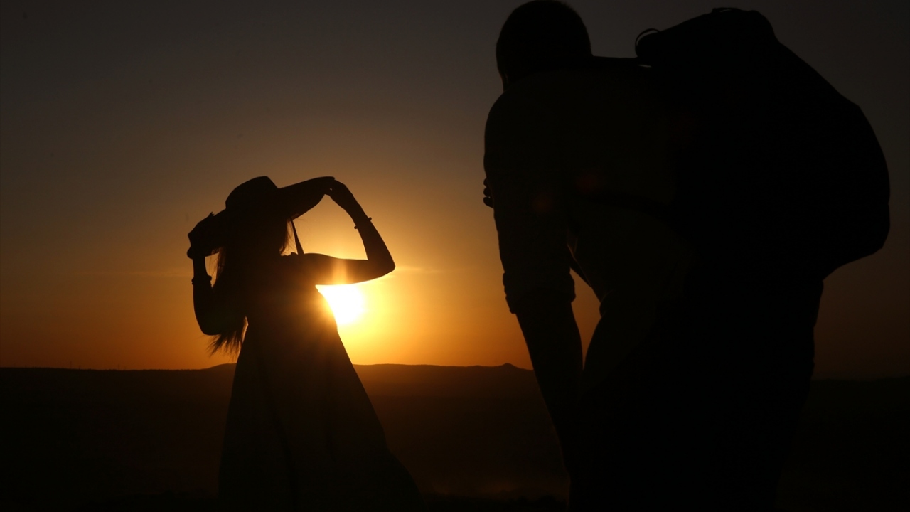 UNESCO Dünya Kültür Mirası Listesi`ndeki bölgede, gün batımını izlemek için vadi girişine gelen konuklar, seyir alanında farklı ışık huzmeleri altında hatıra fotoğrafı çekiyor.