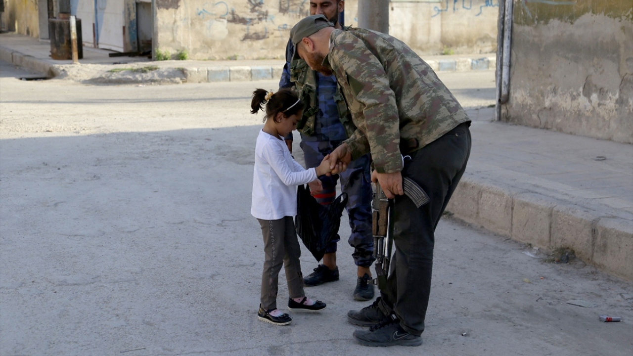 Çocuklar da askerlerin dağıttığı şekerleri kameraya göstererek mutluluklarını yansıttı.