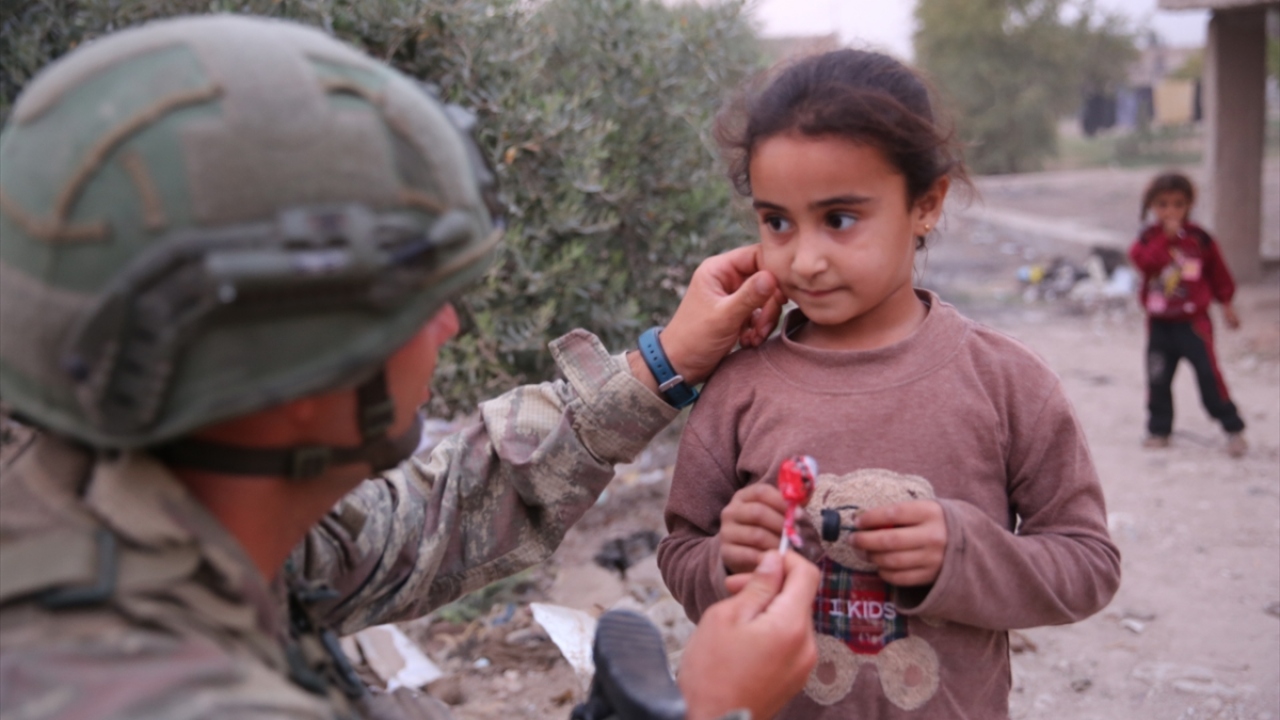 PKK/YPG işgalinden kurtarılan Tel Halaf halkına yardım elini uzatan Mehmetçik, ekmek ve gıda dağıtımı yapılan köyde çocukları çikolata ve şekerle sevindirdi.