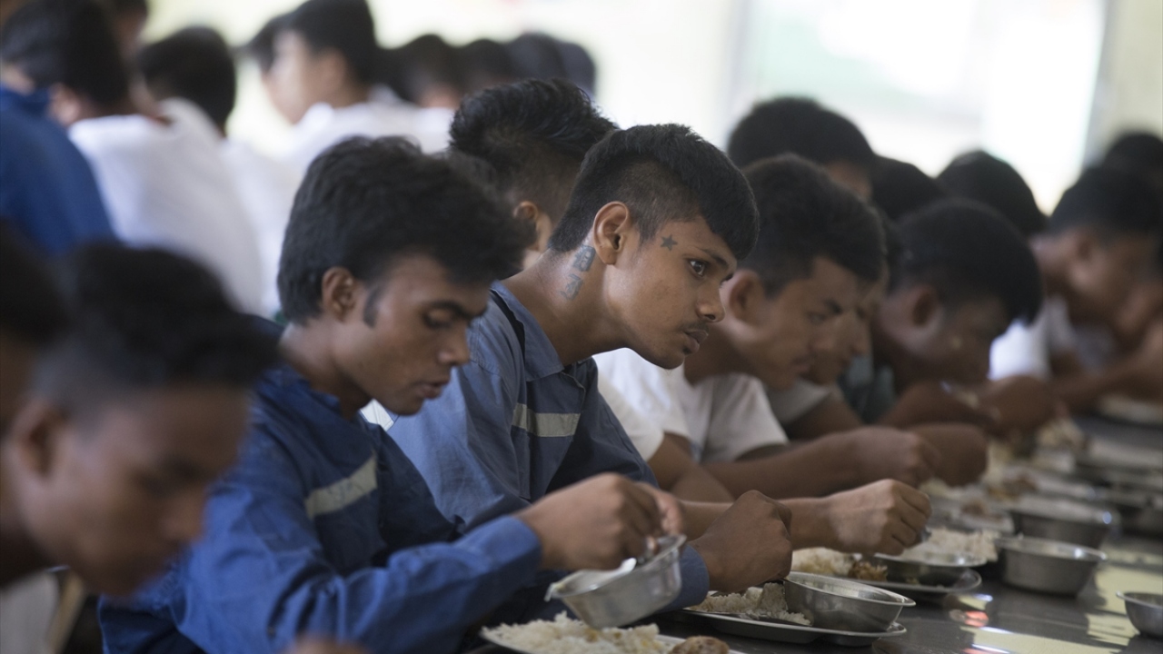 Bir çoğu, Yangon`a ya da ülke dışına izinsiz seyahate teşebbüs ettikleri için hüküm giyerek bu merkeze gönderilen Arakanlı gençler, aralarında Budistlerin de bulunduğu diğer gençlerle beraber ortak yemekhanede yemek yiyorlar.
