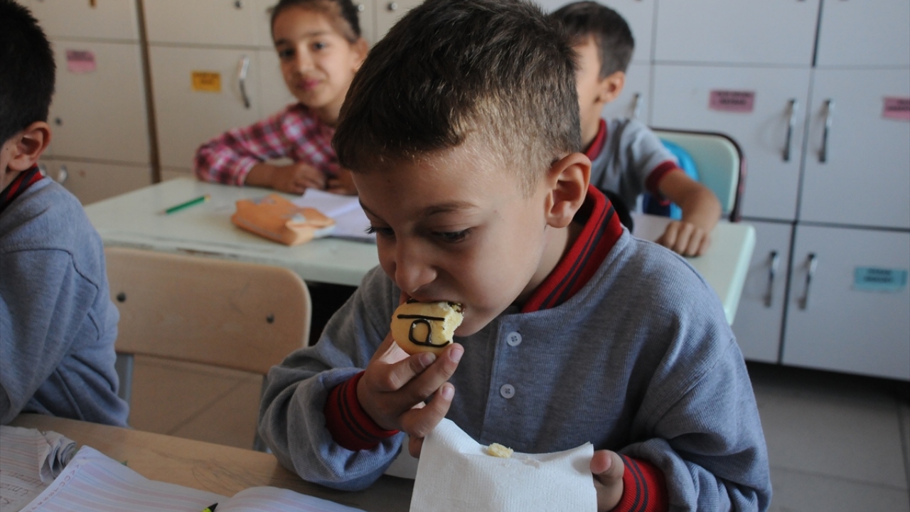 Öğrenciler, kendilerine dağıtılan kurabiyelerin üzerindeki yazıları okuyup, yazmasının ardından yiyebiliyor.
