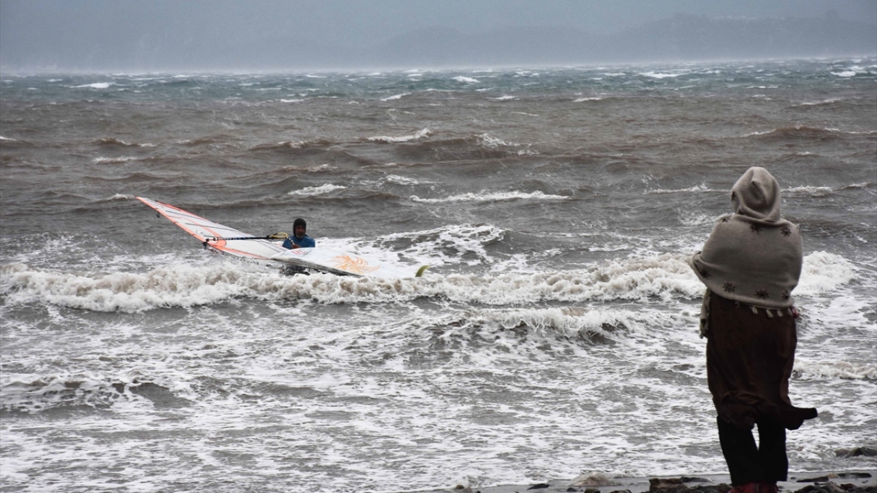 Dalgalar arasında rüzgar sörfü yapanları, sağanağa rağmen vatandaşlar da kıyıdan ilgiyle izledi.