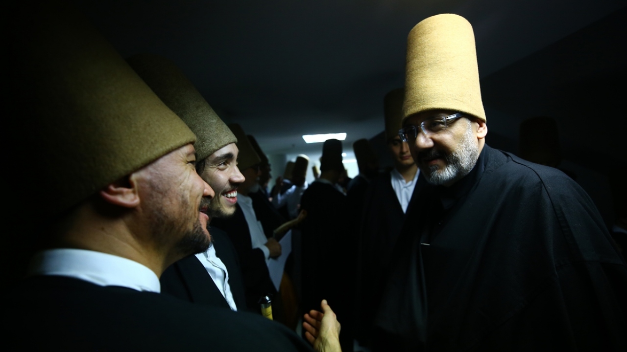 Semazen, ayin sırasında üstündeki siyah hırkayı çıkararak, sembolik olarak hakikate doğarken, kollarını bağlayarak da bir rakamını temsil ediyor. Derviş, böylece Allah`ın birliğine de şehadet etmiş oluyor.