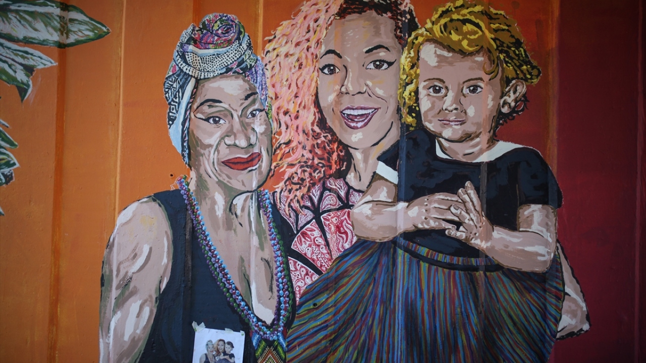 Fotoğrafta aktivist kadınları tasvir eden bir duvar resmi de görülüyor.