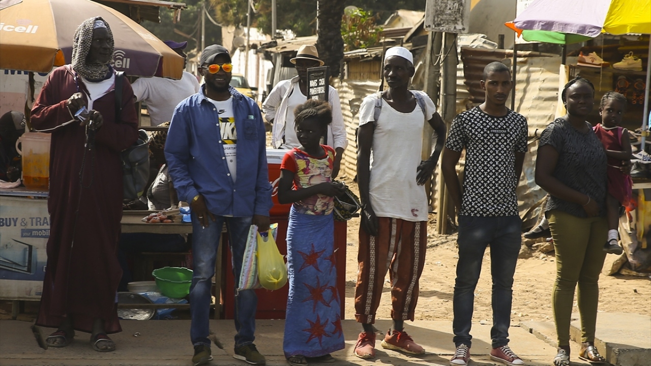 Başkent Banjul`daki vatandaşlar, pazar önünde toplu taşıma aracına binmek için sıra bekliyor.