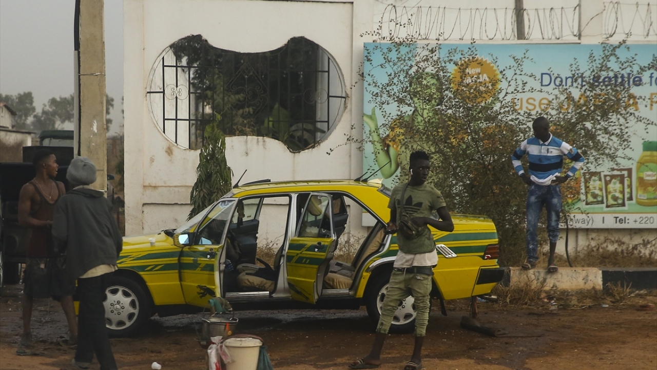 Fotoğrafta, bir taksici arkadaşlarıyla birlikte aracını temizliyor.