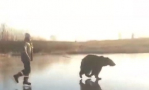 Barınaktan aldığı ayıyla donmuş nehirde buz pateni yaptı