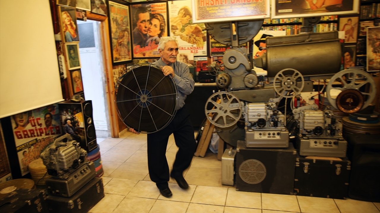 Şenevi, film gösterisi öncesi yaptığı hazırlıkta film makaralarını başa sararak makineye yerleştiriyor.