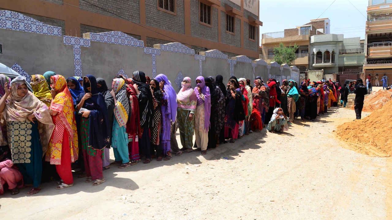 Aile başına verilen 12,000 Pakistan rupisi yardımı için Pakistanlı kadınlar sırada bekledi.