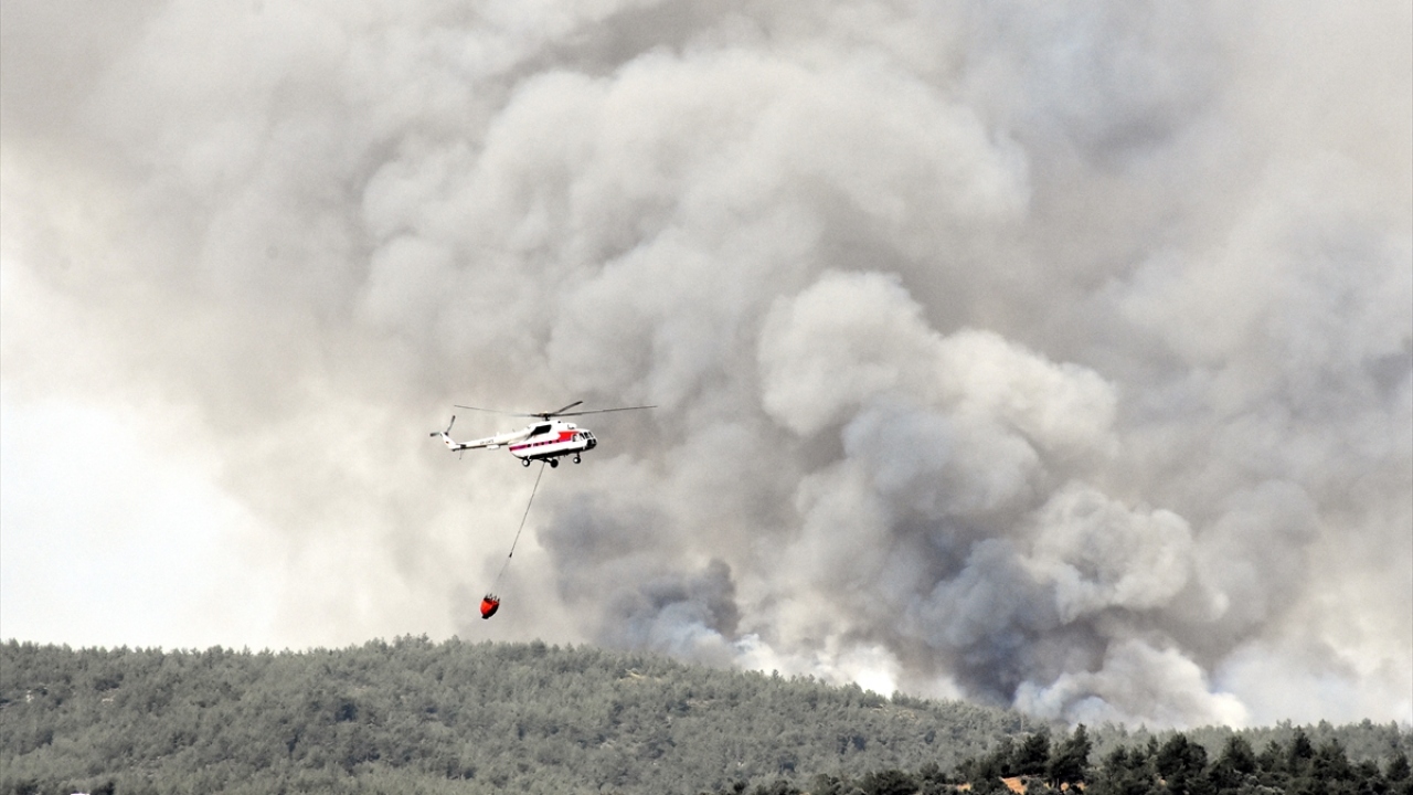 Rüzgarın etkisiyle yayılan yangına, Muğla Orman Bölge Müdürlüğüne ait 2 helikopter, çok sayıda arazöz ve itfaiye ekiplerince müdahale ediliyor.