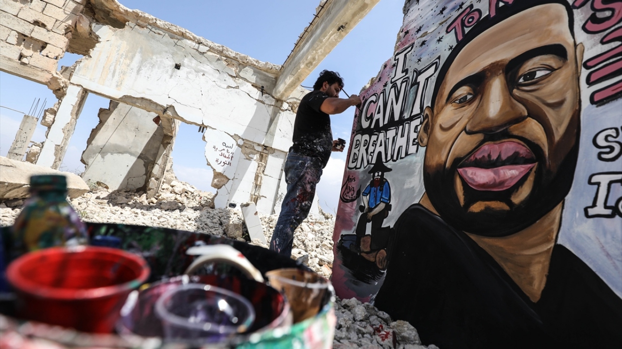 Esmer, bu sefer, Binneş`te hasar gören bir evin duvarına, ABD`nin Minnesota eyaletinin Minneapolis şehrinde bir polis tarafından ensesine dakikalarca basılarak öldürülen George Floyd`un resmini çizdi.