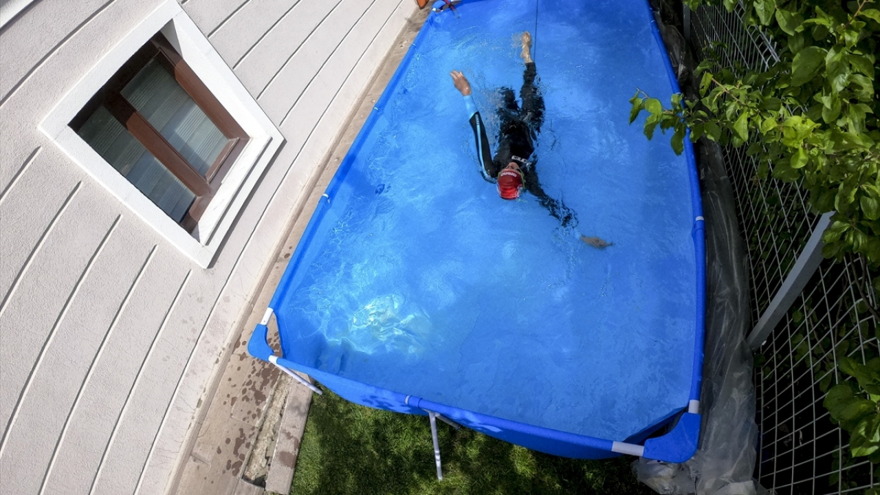 Avşar, 4 metre uzunluğunda, 1 metre derinliğindeki portatif havuzda, soğuktan korunmak için özel giysi ve bele bağlanan bir lastikle antremanlarını gerçekleştiriyor.