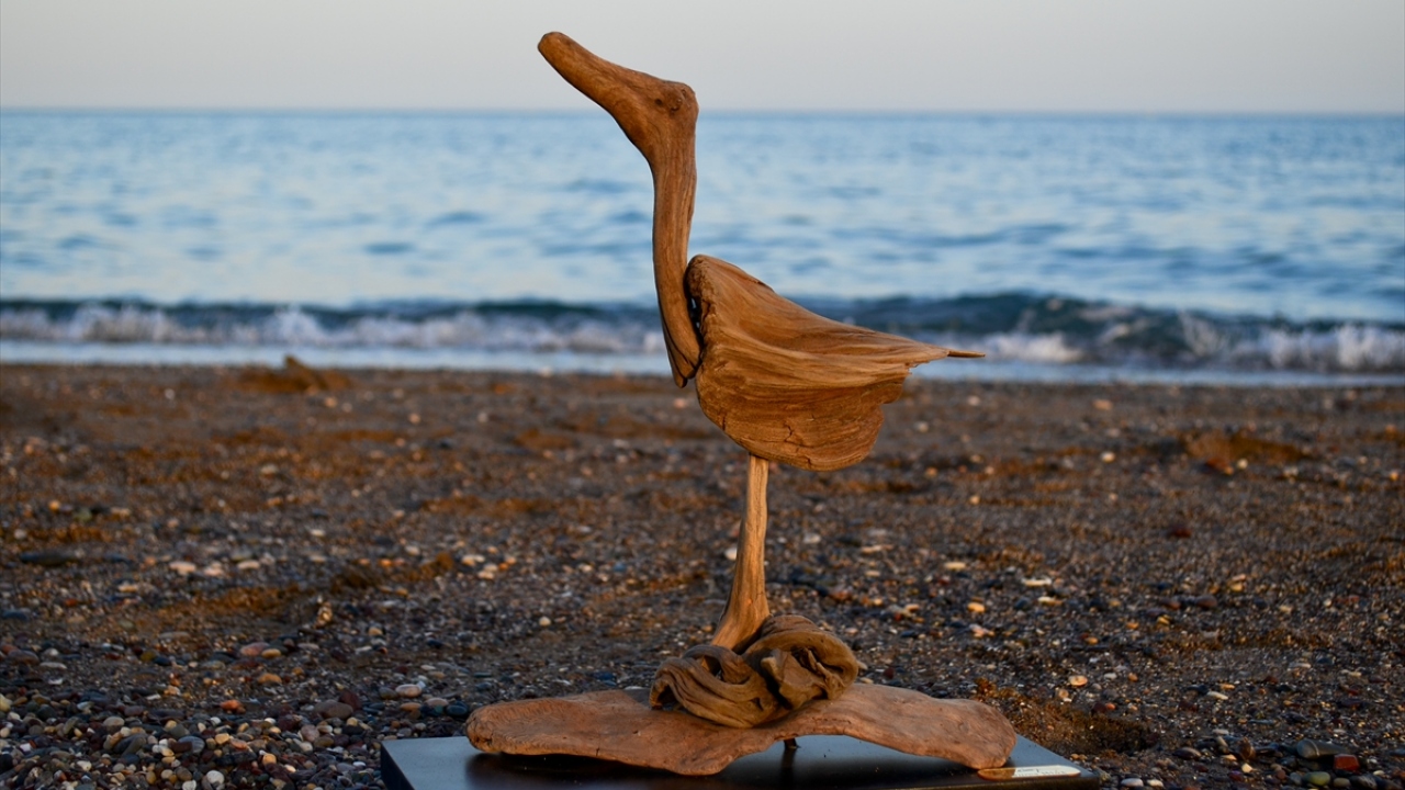 Özel sektörde çalışan 38 yaşındaki Özipek, geçen yıl sahilde gezerken gördüğü, tuzlu su ve rüzgarın etkisiyle renk ve şekil değiştirmiş ağaç parçalarını pimlerle birleştirerek çivi kullanmadan heykel yaptı.