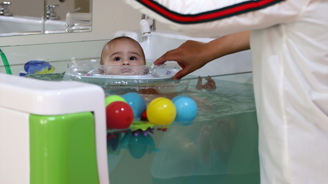 Aileleri tarafından SPA merkezine getirilen bebekler, burada önü camla kaplı jakuzilerde boyun simidiyle yüzdürülüyor. 