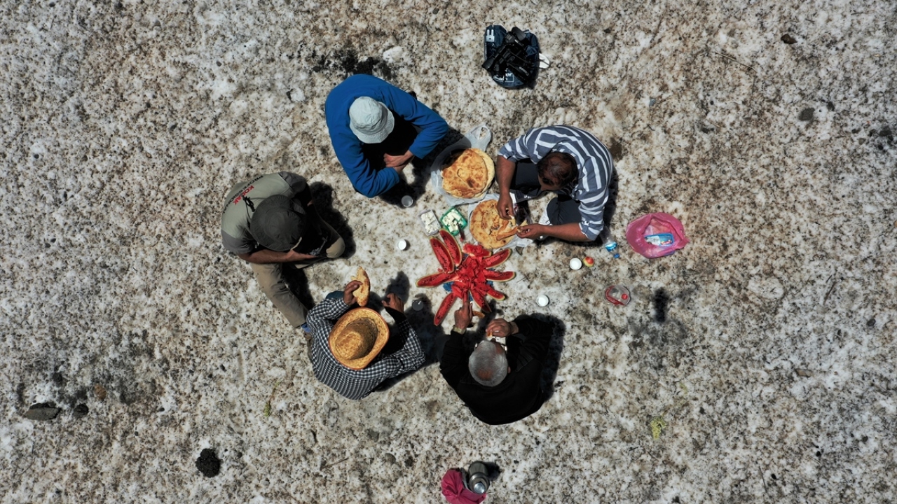 Öğle arası veren ekip kar üstünde yemeklerini yiyor. 