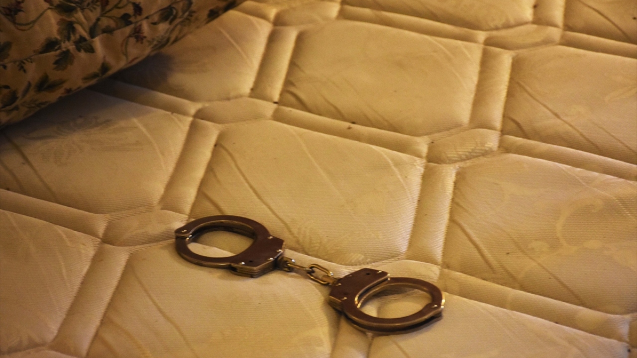 Eli kanlı teröristlerin hain girişimi sırasında çatışmanın yaşandığı otel odasında darbecilere karşı koyan bir koruma polisine ait kelepçe, kan izleri bulunan yatağın üzerinde duruyor. 