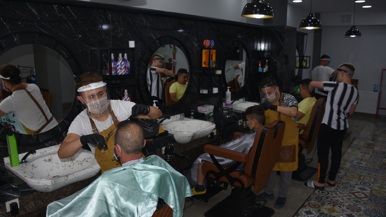 İlçede 22 yıldır berberlik yapan Erdem Şahin, salgın dolayısıyla maske, eldiven ve dezenfektan kullanarak müşterilerinin bayram tıraşını yapıyor.