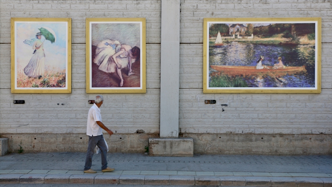 Tablolarla renklenen duvarın önüne gelen vatandaşlar, burada öz çekim yapıyor.
