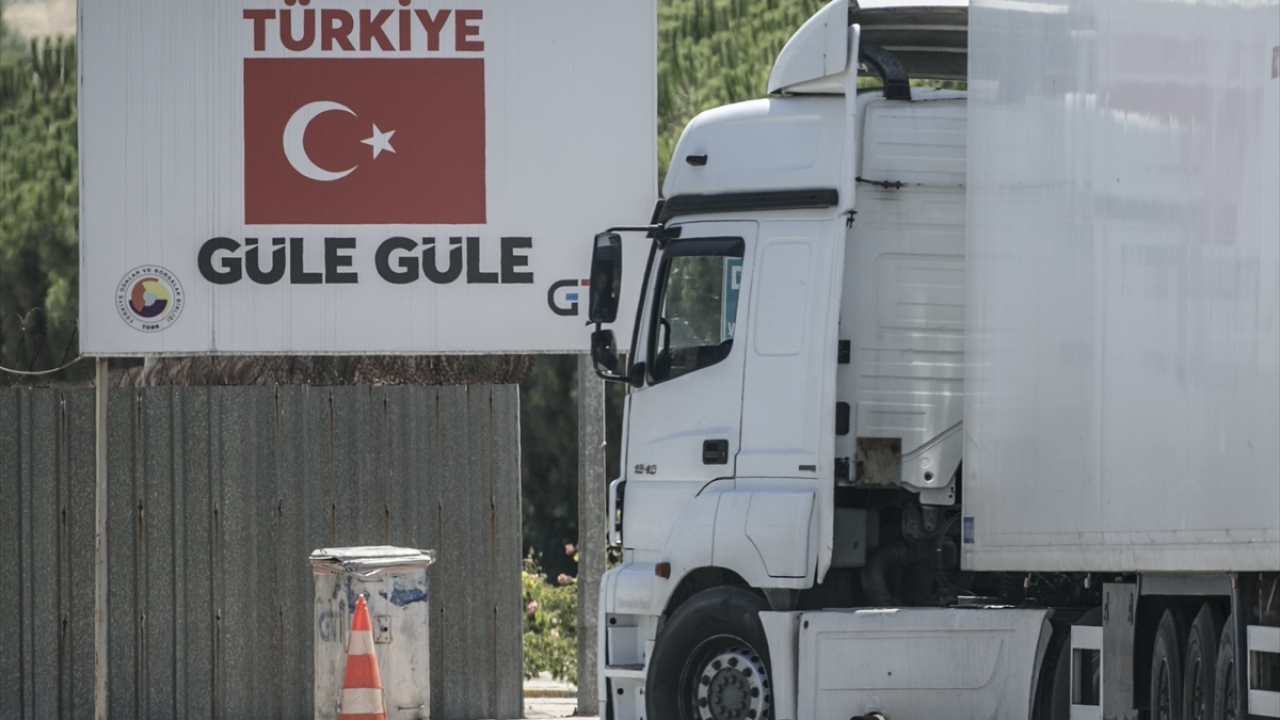 Suriye tarafına geçen tırlar, yüklerini tampon bölgedeki araçlara aktarıp dönüyor. 