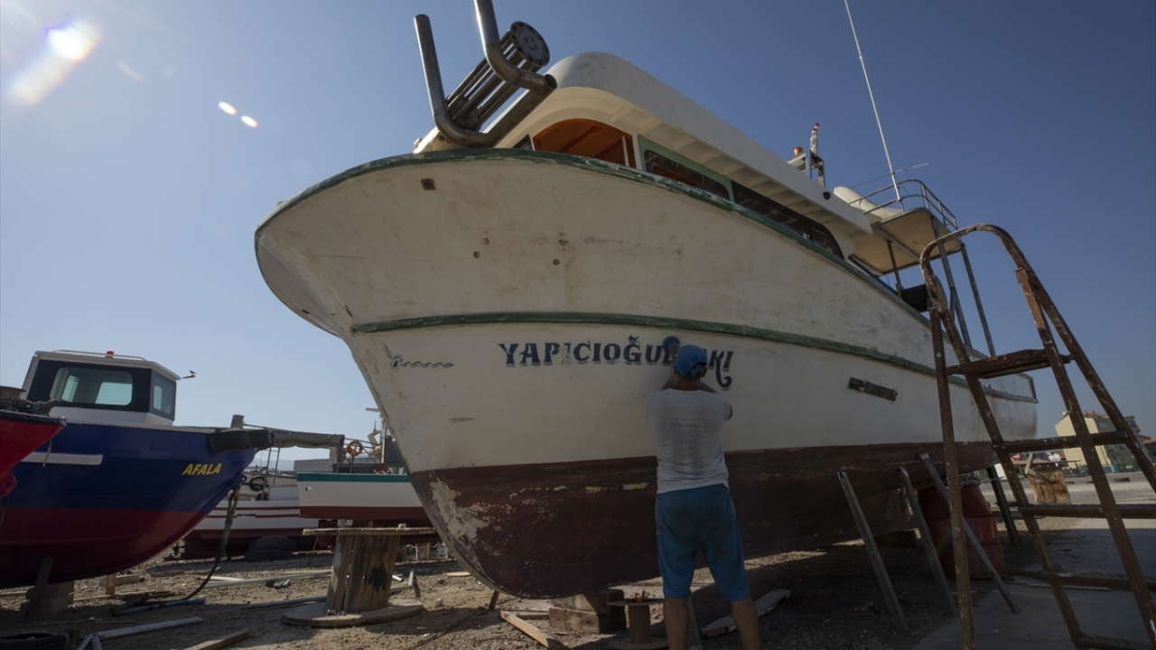 Ege`nin en büyük balıkçı barınaklarından biri olan Güzelbahçe`de ağlarını tamir eden balıkçılar, teknelere son bakımları yapıyor. 