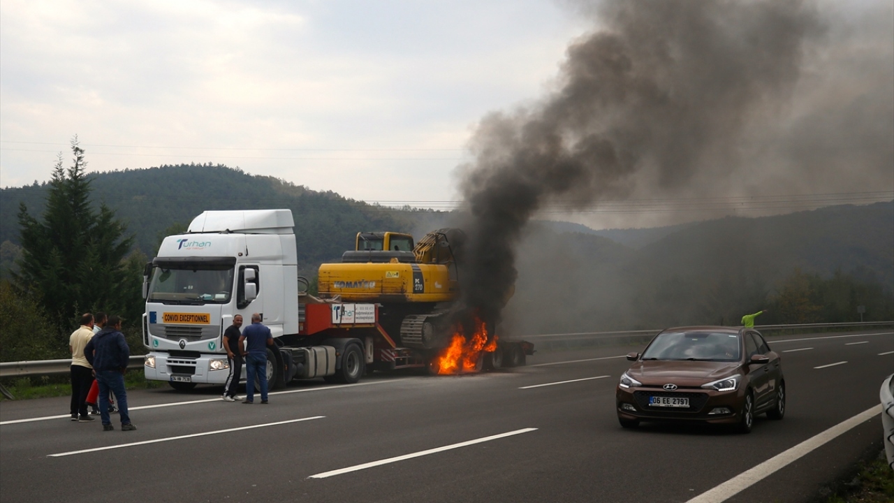 Arif Aydın yönetimindeki 34 HN 7538 plakalı iş makinası yüklü tır`ın, Anadolu Otoyolu`nun Bola Dağı Kaynaşlı Darıyeri Hasanbey mevkisinde dorse bölümünde dumanlar yükseldiğini gören sürücü aracı emniyet şeridine çekti.