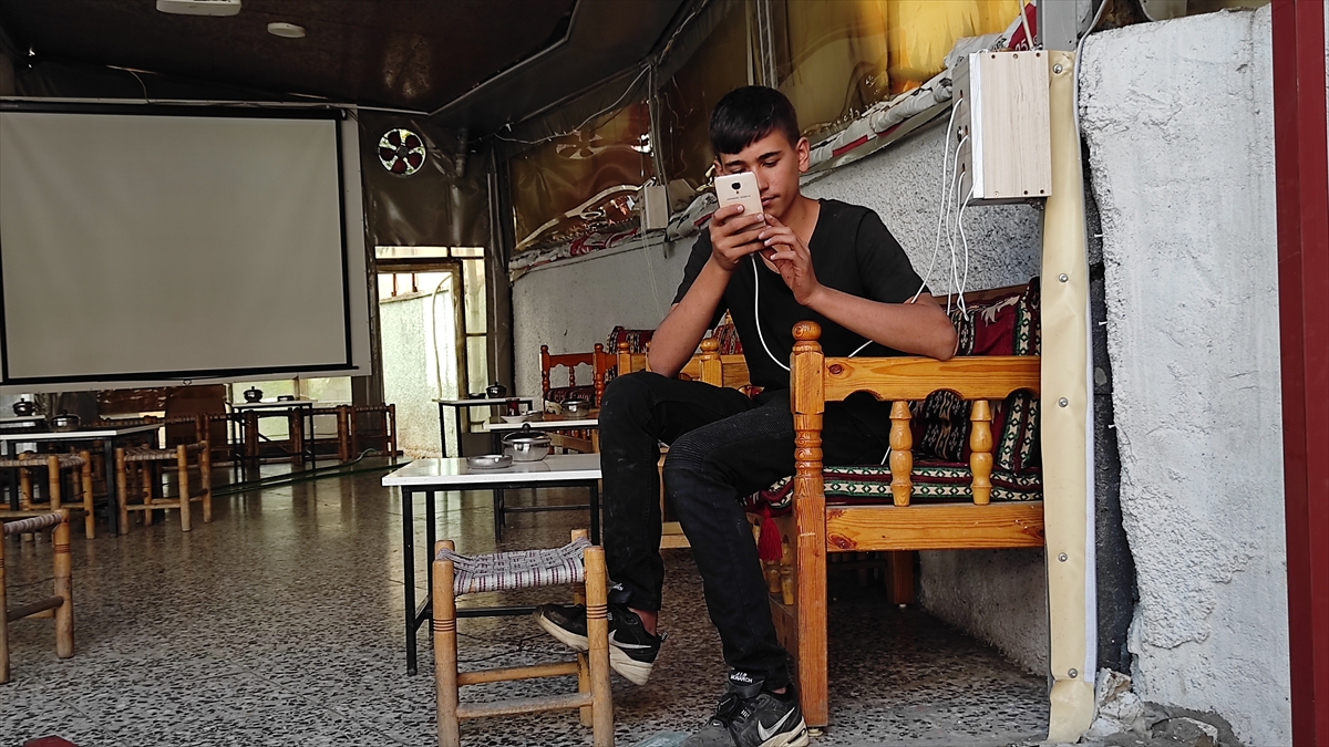 Bingöl Merkez Anadolu İmam Hatip Lisesinde 9. sınıf öğrencisi Berat Uçar, sanayi sitesinde demir doğrama işi yapan babasına yardım ederken derslerini de aksatmamak için babasının cep telefonundan EBA üzerinden derslerini dinliyor.