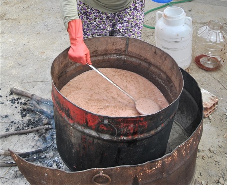 Çocuklarının emekleriyle kendi tecrübelerini birleştiren anneler, koyulaşan karışımı kaplarla alarak teneke leğenlere döküp katılaşmalarını bekledi.