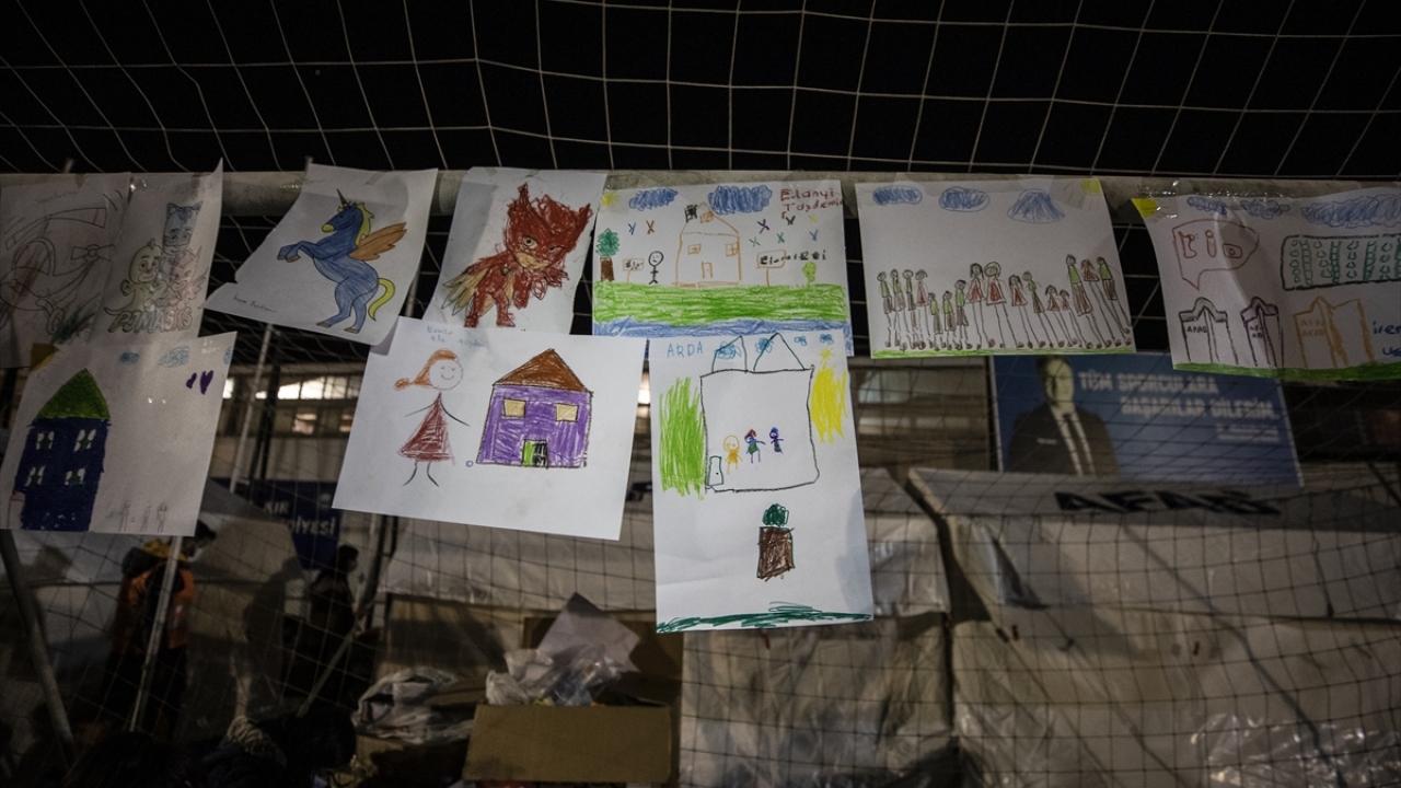 İzmir`de, depremin ardından Bornova Stadyumu`na kurulan çadırlarda barınan ailelerin çocukları, gönüllüler eşliğinde yaptıkları resimleri kale direğinde sergiliyor.