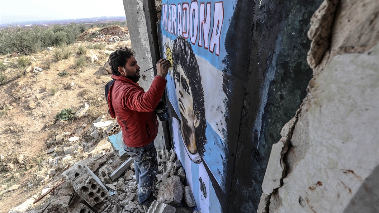 İdlib`in Binniş ilçesinde yaşayan 36 yaşındaki grafiti sanatçısı Aziz Esmer, Beşşar Esed rejimi ve destekçilerinin saldırıları nedeniyle ilçede hasar gören bir evin duvarına, Maradona`nın resmini çizdi.