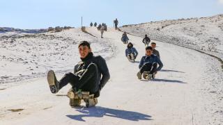 Çocuklar karlı tepeleri kayak pistine dönüştürdü