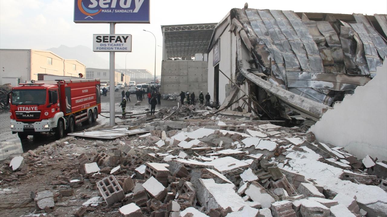 Soğutma çalışmalarının devam ettiği fabrikadaki yanan masa ve sandalyeler iş makinesiyle fabrika dışına çıkarılmaya çalışılıyor.