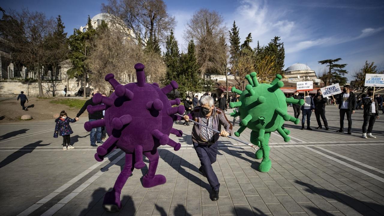 Maske takmayan kişilere yaklaşan virüs maskotu, onlara sarılmaya çalışarak virüsün bulaşıcılığına dikkat çekti. 