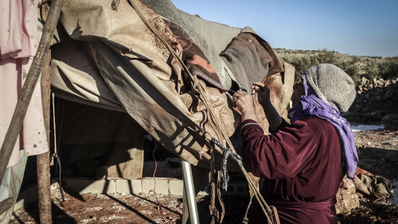 Suriye`de Beşşar Esed rejiminin saldırılarından kaçarak kamplara sığınan İdlibli aileler, kış şartlarından zarar gören çadırlarını iğne iplikle onararak soğuk ve yağmurla mücadele ediyor.