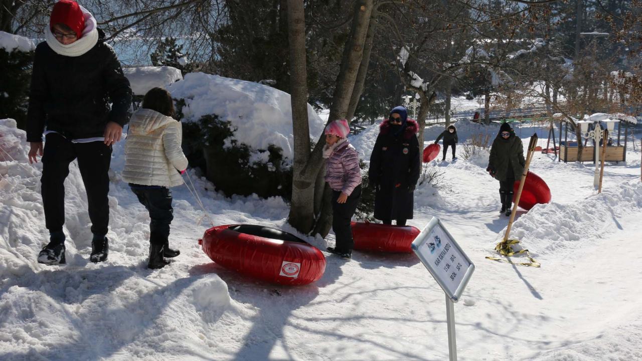 Bazı tatilciler ise otellerin yakınlarında oluşturulan kayak alanlarında şambrelle kaydı.
