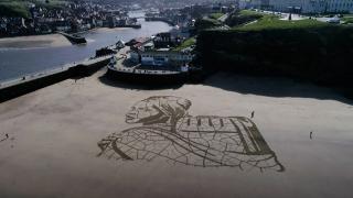 İklim değişikliğine dikkat çekmek için kumsala portre çizdi