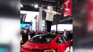 Tesla'ya ilginç protesto: Fuarda arabanın üzerine çıkarak bağırdı